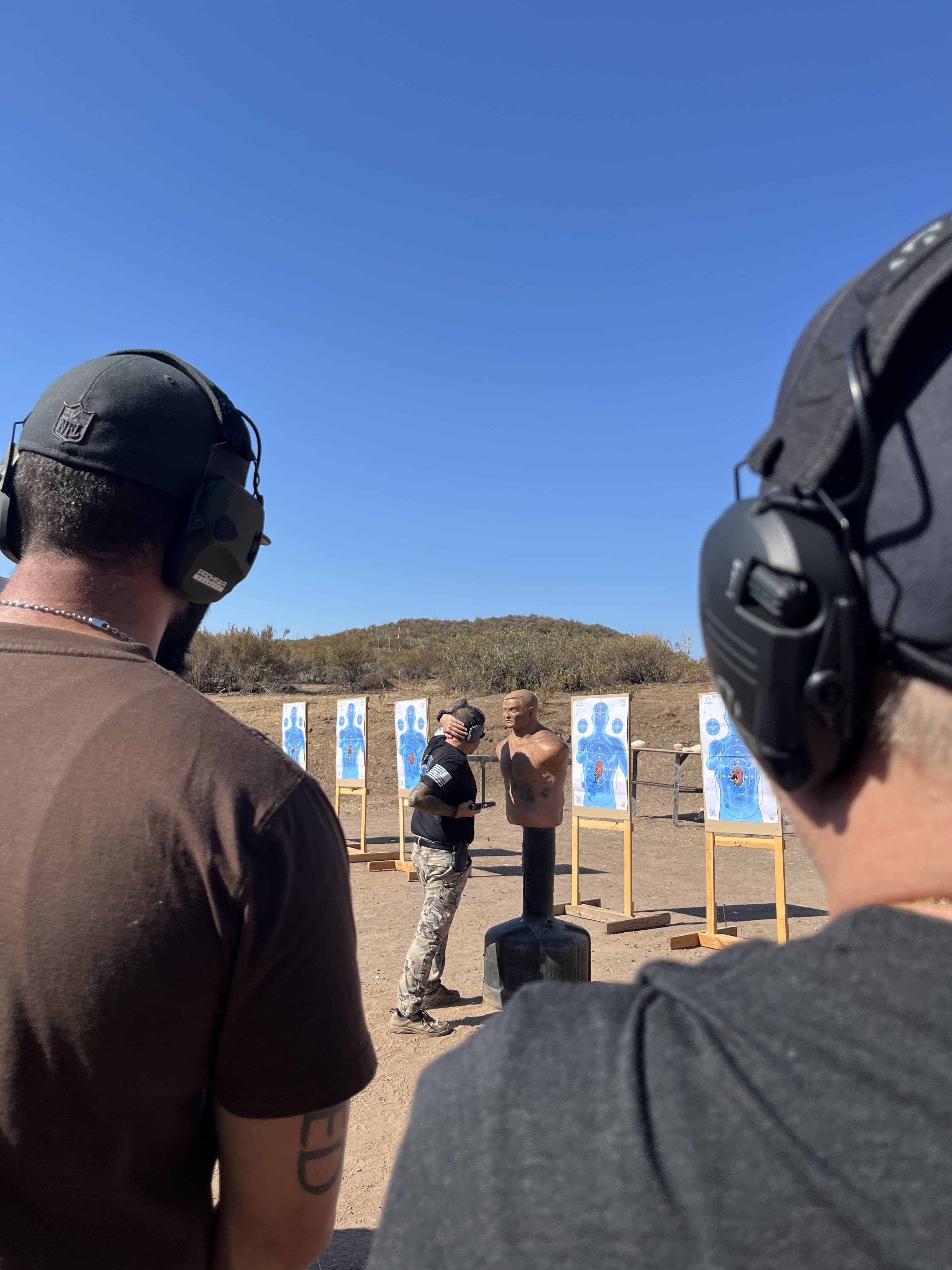 A CTI Instructor is demonstrating a Close-Quarter-Combat drill while 2 students observe